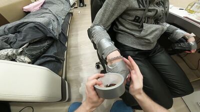 Silver tape tied to chair, leather pants, sock gagged