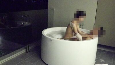 Asian couple having sex in an outdoor jacuzzi, someone is peeking.