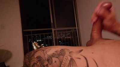 Colombiano se hace una rica paja en su cama con vista a la ciudad hasta venirse.